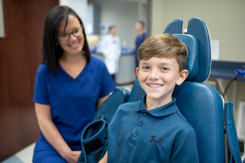 Dental assistance with young boy in examine room